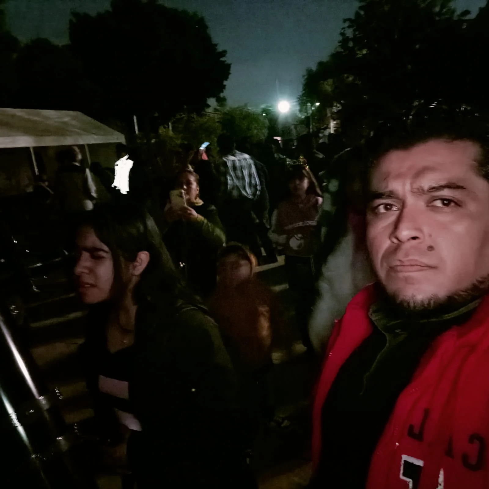 Participantes reunidos al aire libre durante la noche.